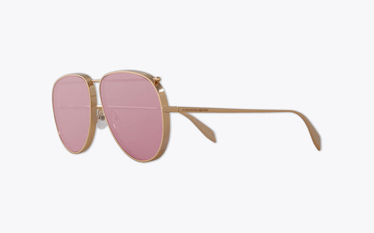 Alexander McQueen Piercing 170S Aviator sunglasses with pink lenses and gold frame on a off-white background