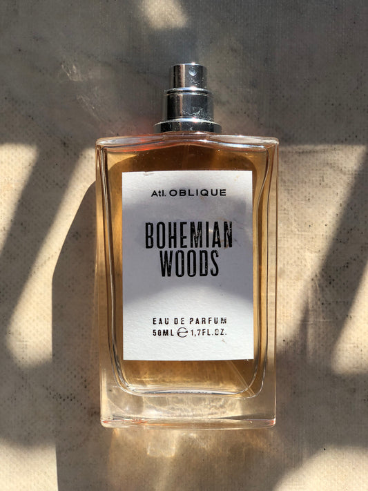 Perfume bottle labeled 'Bohemian Woods' by Atelier Oblique on a textured surface.