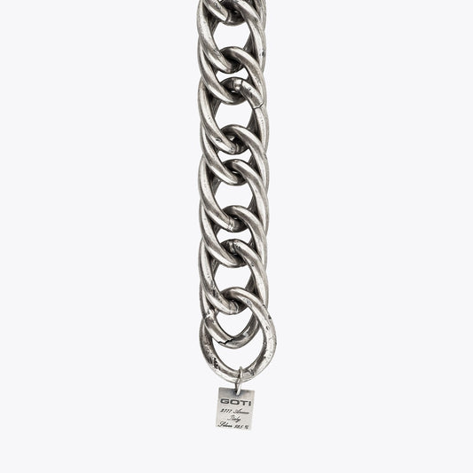 Silver link chain bracelet with a visible brand tag on a white background