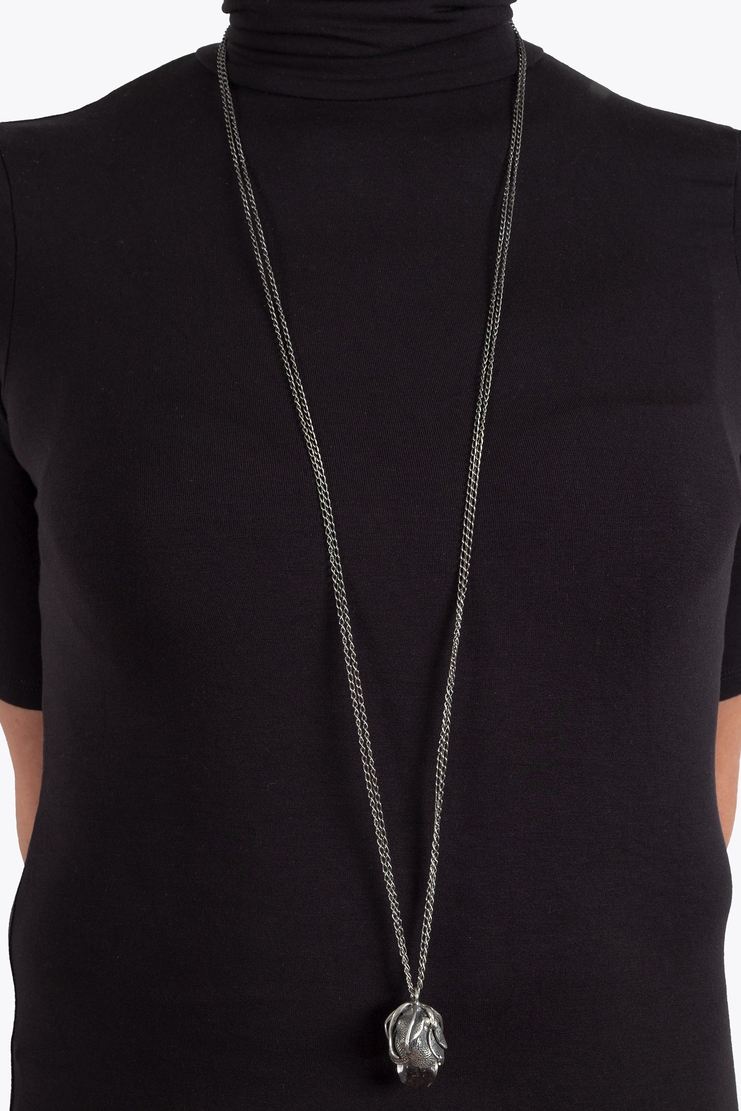 Long necklace with a pendant on a black turtleneck